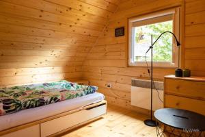 a bedroom with a bed in a wooden cabin at Domek nad Zalewem Radkowskim in Radków