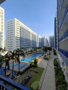 a view of a city with two pools and palm trees at Sea Residences MOA -PaulJade Place in Manila
