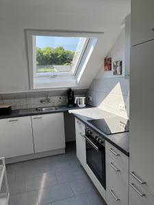 een witte keuken met een raam en een wastafel bij Zur Stadtmama in Endingen