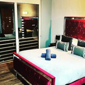 Schlafzimmer mit einem großen Bett mit einem roten Kopfteil in der Unterkunft Gran Santiago Apart in Santiago