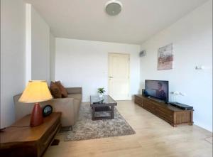 a living room with a couch and a flat screen tv at 350 METER BEACH , Center of the City in Hua Hin