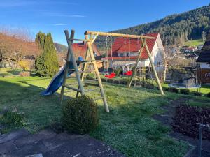 a park with a swing set in the grass at Ferienhaus Burghalde mit Sauna in Alpirsbach