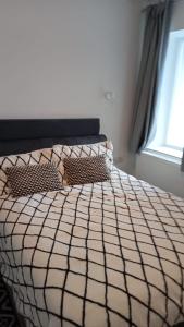 a bedroom with a bed with two pillows and a window at Bike Park 5 miles2-Bed cottage in Merthyr Vale in Merthyr Tydfil