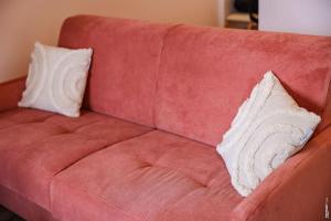 a red couch with two pillows on it at L' Ecume de Montaudry - Terrasse - Albi in Albi