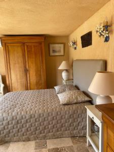 ein Schlafzimmer mit einem Bett mit zwei Lampen und zwei Tischen in der Unterkunft L’oiseau bleu in Cotignac