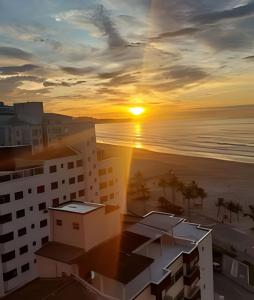 vistas a la puesta de sol desde un edificio en Em frente ao quiosque Ocian na praia, pé na areia, en Praia Grande