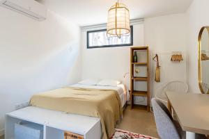 een slaapkamer met een bed, een tafel en een raam bij Le LilaRosa, Terrasse, Clim, Pkg, Centre Ville in Montpellier