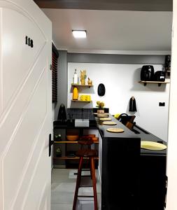 una cocina con una isla negra en una habitación en Em frente ao quiosque Ocian na praia, pé na areia, en Praia Grande