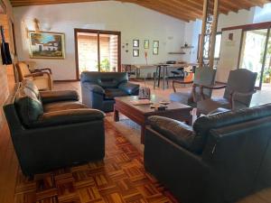 sala de estar con muebles de cuero y mesa en FINCA VERDI, en Girardota