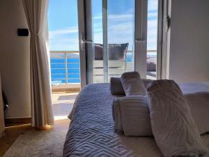 a bedroom with a bed with a view of the ocean at Βeachfront Luxury Apartments SARANDE in Sarandë