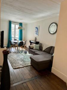 a living room with a couch and a table at Paris - Appartement 50m2 - Tour Eiffel in Paris