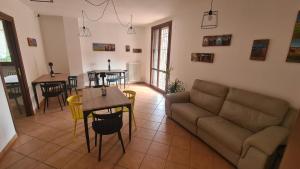 ein Wohnzimmer mit einem Sofa, einem Tisch und Stühlen in der Unterkunft Ca' Lambru in Castelnovo di Sotto