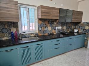 a kitchen with blue cabinets and a sink at Swayamkrushi 2nd Floor in Hyderabad