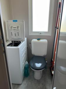 a small bathroom with a toilet and a window at Mobil home neuf 6 p à Hyères dans camping 4 étoiles Les Pins Maritimes in Hyères