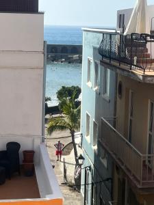 una persona caminando por la playa entre dos edificios en Casa El Puerto en Puerto
