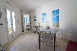 a dining room with a table and chairs and windows at Villetta Amelie a Otranto in Otranto +20 photos
