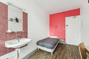 Habitación pequeña con cama y lavamanos en Hotel Tolbiac en París