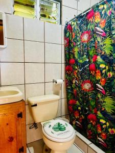 een badkamer met een toilet en een douchegordijn bij Cabaña Palo Alto in Barva