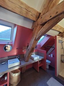 baño con paredes rojas y vigas de madera en La Parenthèse à Etrigny, en Étrigny