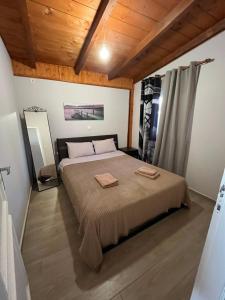 1 dormitorio con 1 cama con 2 toallas en Luxury house 15 minutes from ATH en Spáta