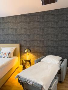 twee bedden in een kamer met een muur bij Exklusives Leipzig City Apartment Aurora in Leipzig