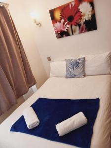 a bed with a blue and white blanket on it at F304-Lovely 3rd Flr Studio fits 2 Near Hyde Park in London