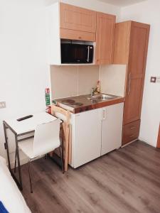 a small kitchen with a sink and a table at F304-Lovely 3rd Flr Studio fits 2 Near Hyde Park in London