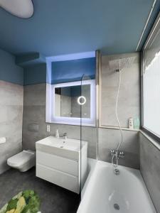 a bathroom with a tub and a sink and a toilet at Exklusives Leipzig City Apartment Aurora in Leipzig