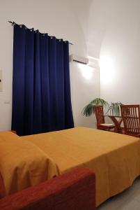 レッチェにあるAppartamento B&B Ariostoのベッドルーム1室(青いカーテン付きのベッド1台付)