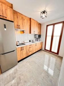 a kitchen with wooden cabinets and a refrigerator at Refugio acogedor en Vilaflor in Vilaflor