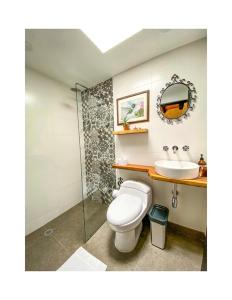a bathroom with a toilet and a sink at Eco Hotel Hacienda El Diamante in Buga