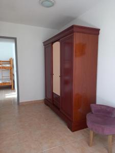 un armario de madera y una silla morada en una habitación en Gite 135 C, en Sarrians
