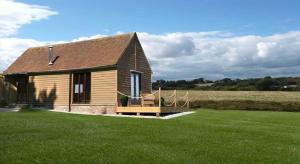 a small house in a field with a grass yard at Knelle Dower Studio in Northiam