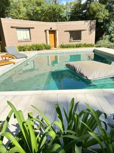 a swimming pool with a bed and a house at ASM APART VII in Merlo