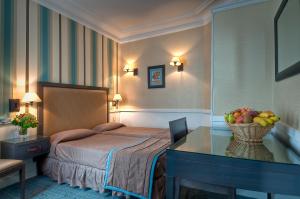 Una habitación de hotel con una cama y una mesa con un bol de fruta. en Elysees Apartments, en París