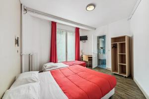 um quarto com 2 camas e um cobertor vermelho em Hotel Tolbiac em Paris