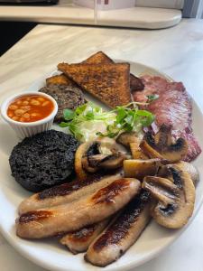 a plate of food with sausage and mushrooms and toast at Airlie Arms Hotel in Kirriemuir