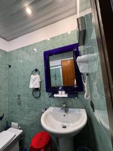 La salle de bains est pourvue d'un lavabo et d'un miroir. dans l'établissement Delle Nazioni Milan Hotel, à Milan