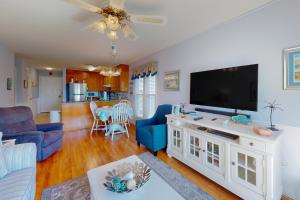 マートルビーチにあるEmerald Pointe 1-Cのリビングルーム(薄型テレビ、青いソファ付)