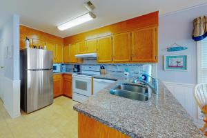 マートルビーチにあるEmerald Pointe 1-Cのキッチン(木製キャビネット、ステンレス製の冷蔵庫付)