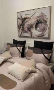 1 dormitorio con 2 camas con almohadas y una foto en appartement résidence Palm Beach Saidia, en Oujda