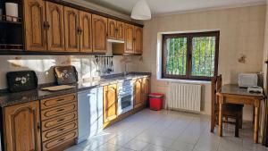 a kitchen with wooden cabinets and a counter top at Casa de Aldea la Piniella in Villahormes