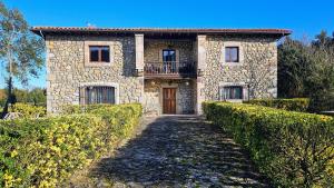 una casa de piedra con un camino que conduce a ella en Casa de Aldea la Piniella, en Villahormes
