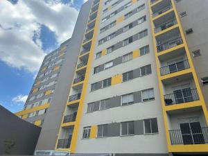 a tall apartment building with yellow accents at Apê da Sil in São Paulo