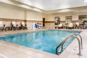 una piscina en un hotel con mesas y sillas en Comfort Inn & Suites Porter near Indiana Dunes, en Porter