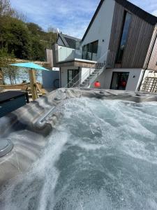 a swimming pool in front of a house at Gulland 4 Bed Sleeps 8 with Hot tub in Treknow