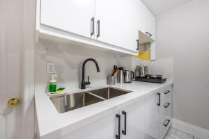 a kitchen with white cabinets and a sink at Niagara Nest - Comfy 1BR and 1BA Close to the Falls in Niagara Falls