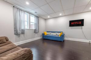 a living room with a couch and a sign on the wall at Niagara Nest - Comfy 1BR and 1BA Close to the Falls in Niagara Falls +8 photos