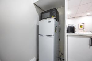 a microwave on top of a refrigerator in a kitchen at Niagara Nest - Comfy 1BR and 1BA Close to the Falls in Niagara Falls