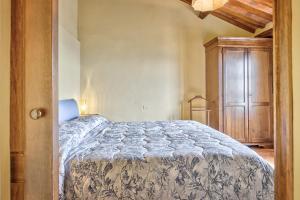 a bedroom with a bed and a wooden cabinet at La Terrazza - Together in Tuscany in Cortona